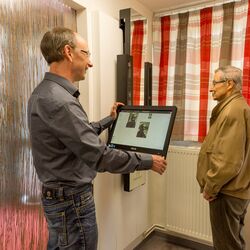 Beratungsgespräch: Der Optiker fotografiert einen Kundinen mit Brillengestell.