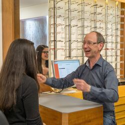 Beratungsgespräch: Der Optiker sucht mit einer Kundin ein Brillengestell aus.